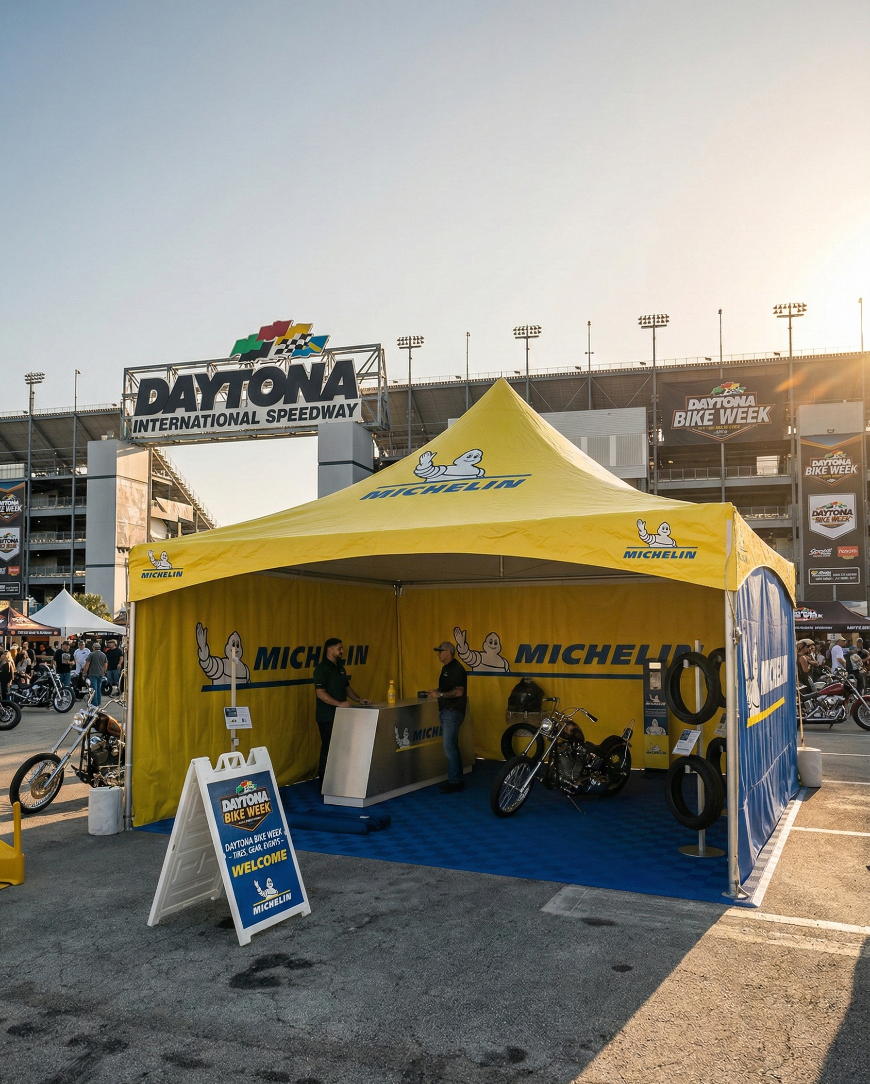 A yellow Michelin tent with motorcycles and tires features an experiential marketing photo booth outside Daytona International Speedway during Bike Week.