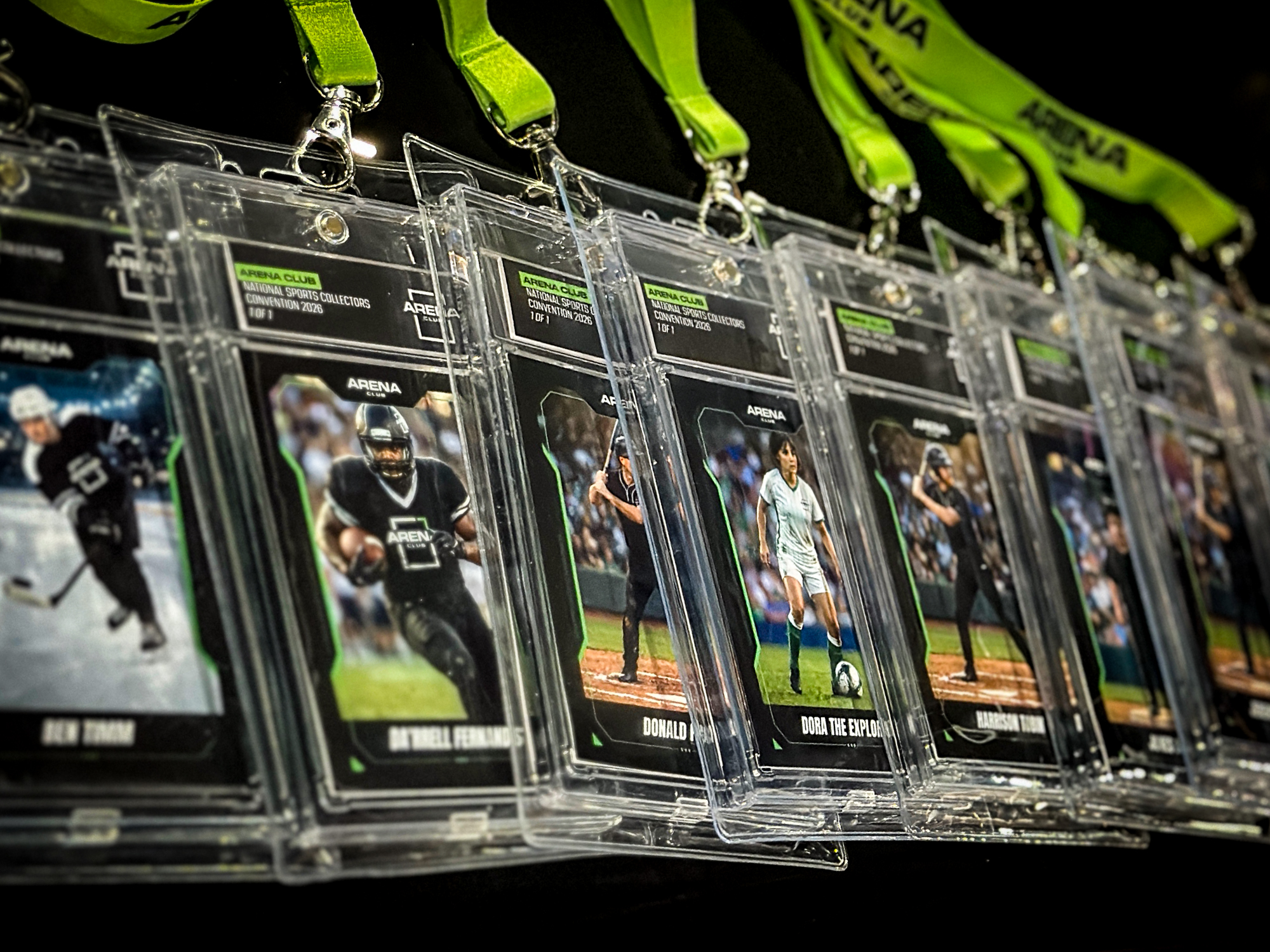A row of plastic lanyards with custom trading cards featuring athletes in action highlights a unique sports marketing activation displayed on a table.