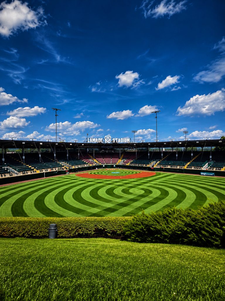 A baseball field at Lamade Stadium with striped green grass, empty stands, and a blue sky—perfect for an Arena Club Trading Card Photo Booth Rental moment.